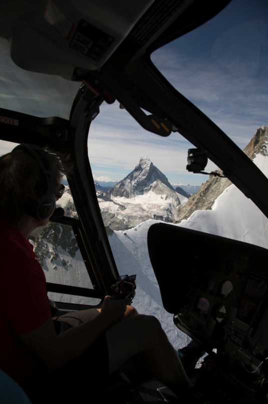 Der Pilot des Helikopters im Hintergrund das Matterhorn in Zermatt beim Helikopterrundflug