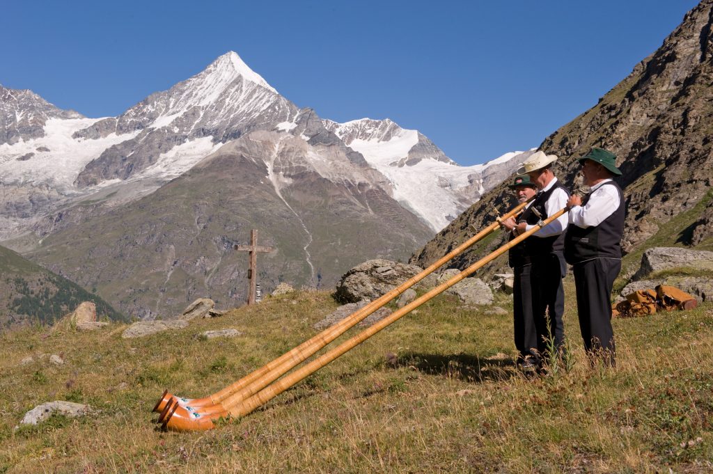 Männer mit langen Trompeten vor dem Matterhorn