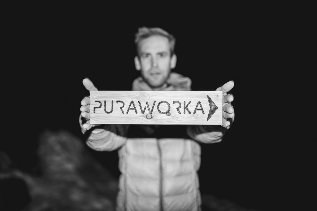 Neil Beecroft holding up a wooden PuraWorka sign.