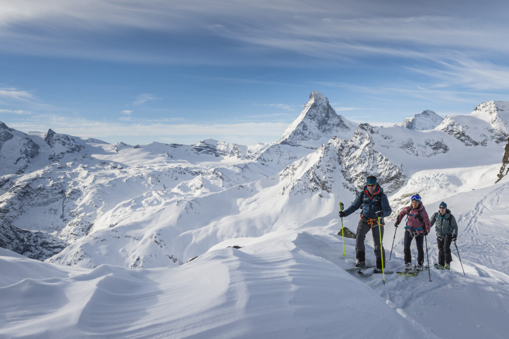 Skitouring mit einem Bergführer vor dem Matterhorn.